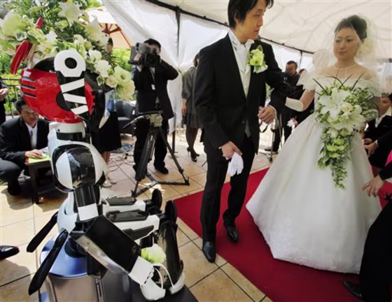 I-Fairy, a four-foot tall seated robot with flashing eyes and plastic pigtails, directs a wedding ceremony for groom Tomohiro Shibata 42, and bride Satoko Inouye, 36, at a Tokyo restaurant on Sunday.